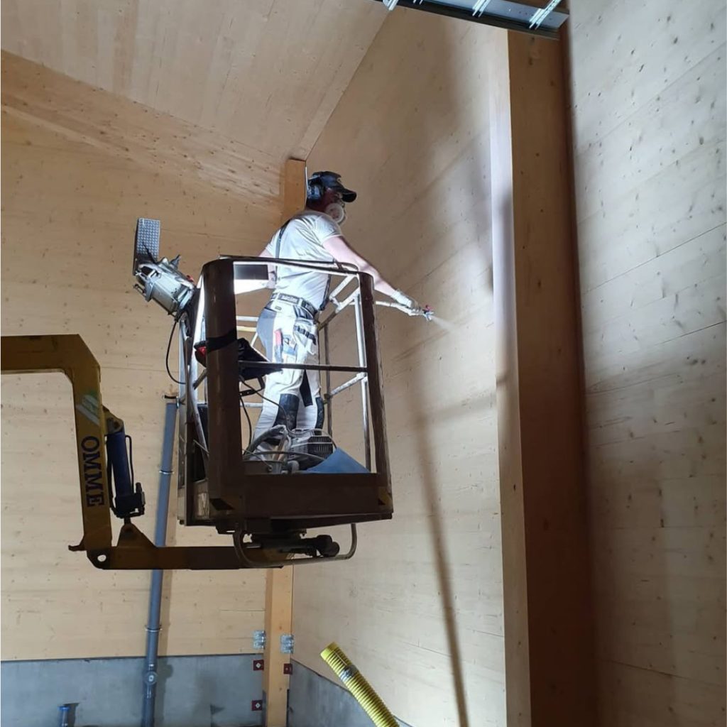 Målare i skylift sprutmålar trästommen i ICA Lindvallen