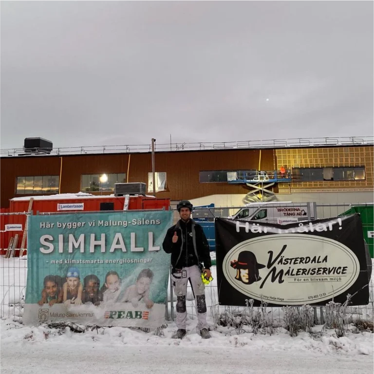Målare vid bygget av Malung-Sälens simhall, med Peabs och Västerdala Måleriservices skyltar