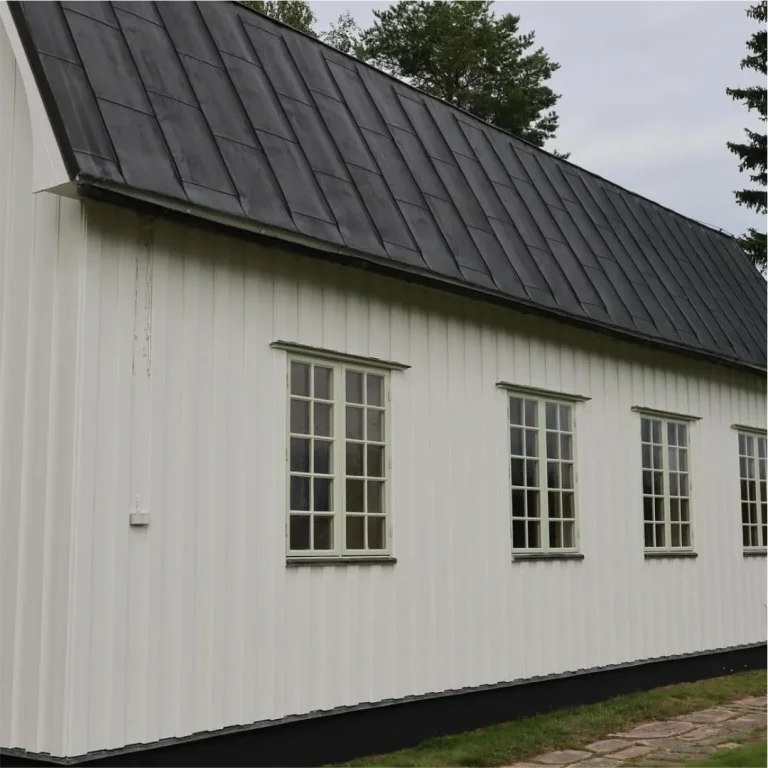 Långsidan av Öje kapell med vit panel och spröjsade fönster