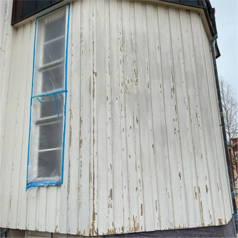 Flagnande färg på fasadpanelen på Yttermalungs kapell före målning, fönstret maskerat